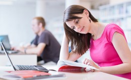 in the library – pretty female student with laptop and books wor